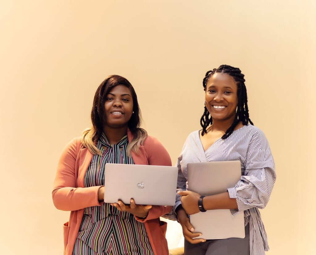 African businesswomen collaborating on laptops in a modern office