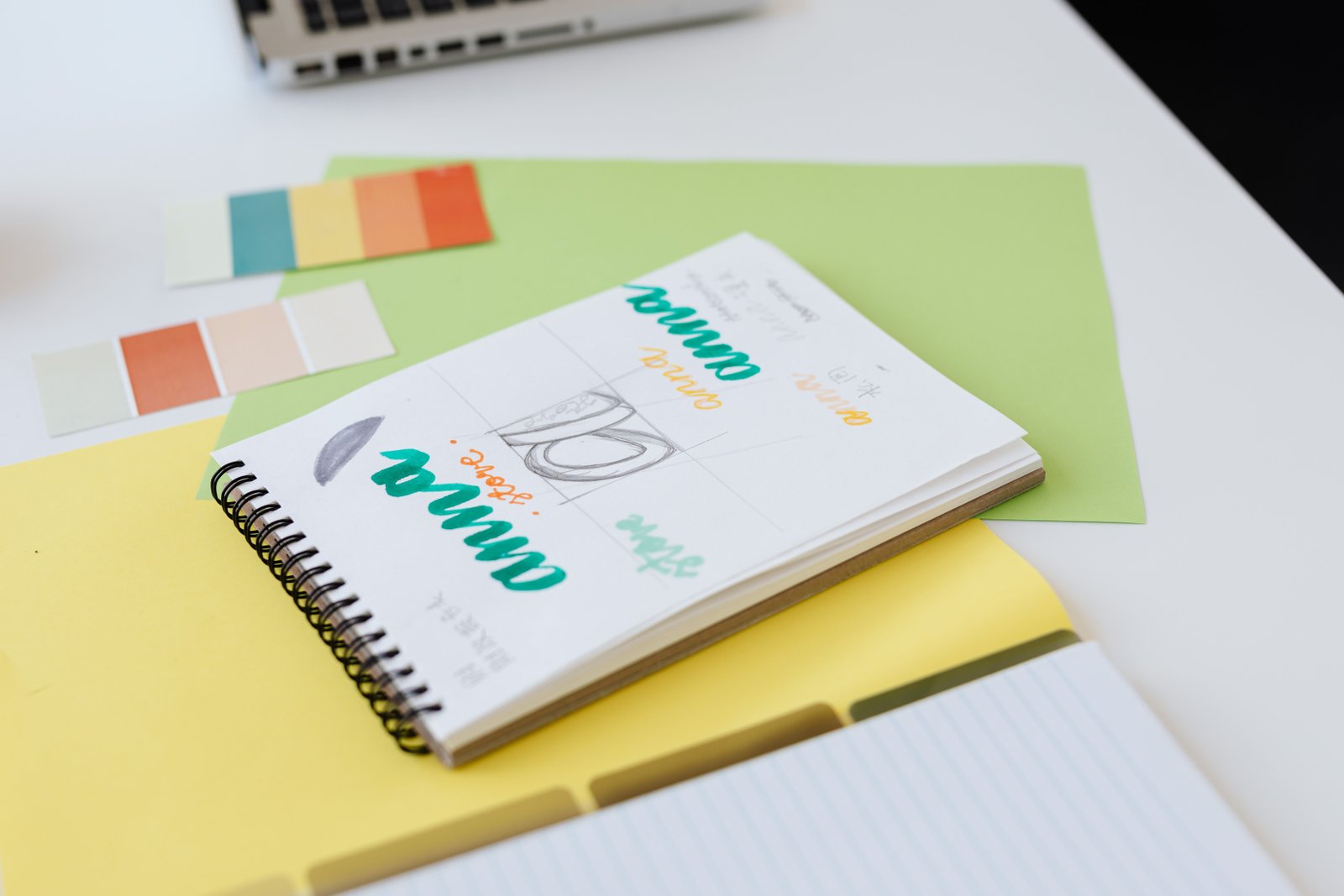 Colorful logo and brand design sketches in a notebook with color swatches