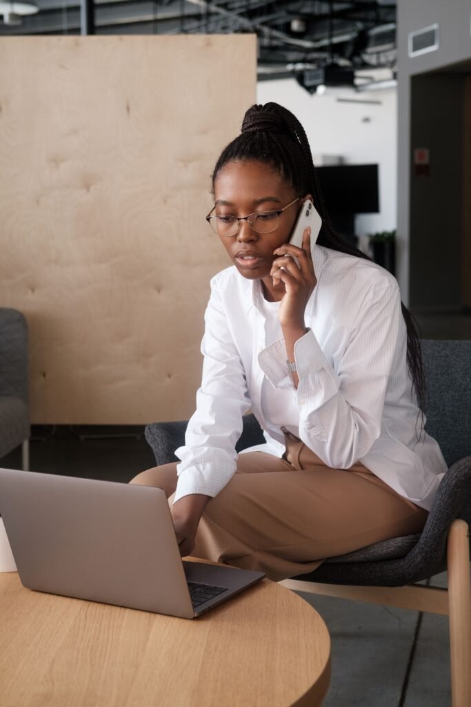Businesswoman on a phone call while working on a laptop