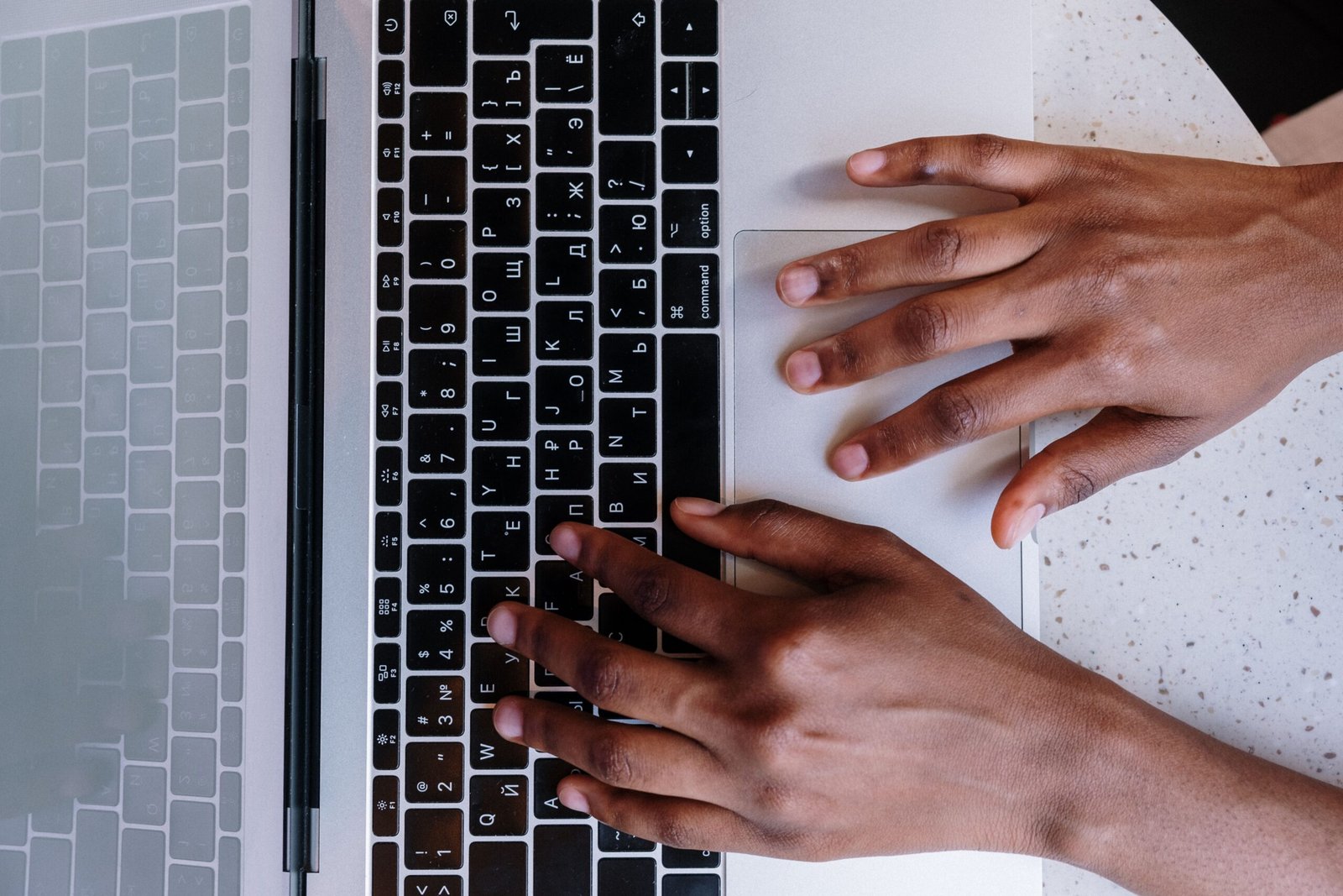 Hands typing SEO content on a laptop keyboard for a business website