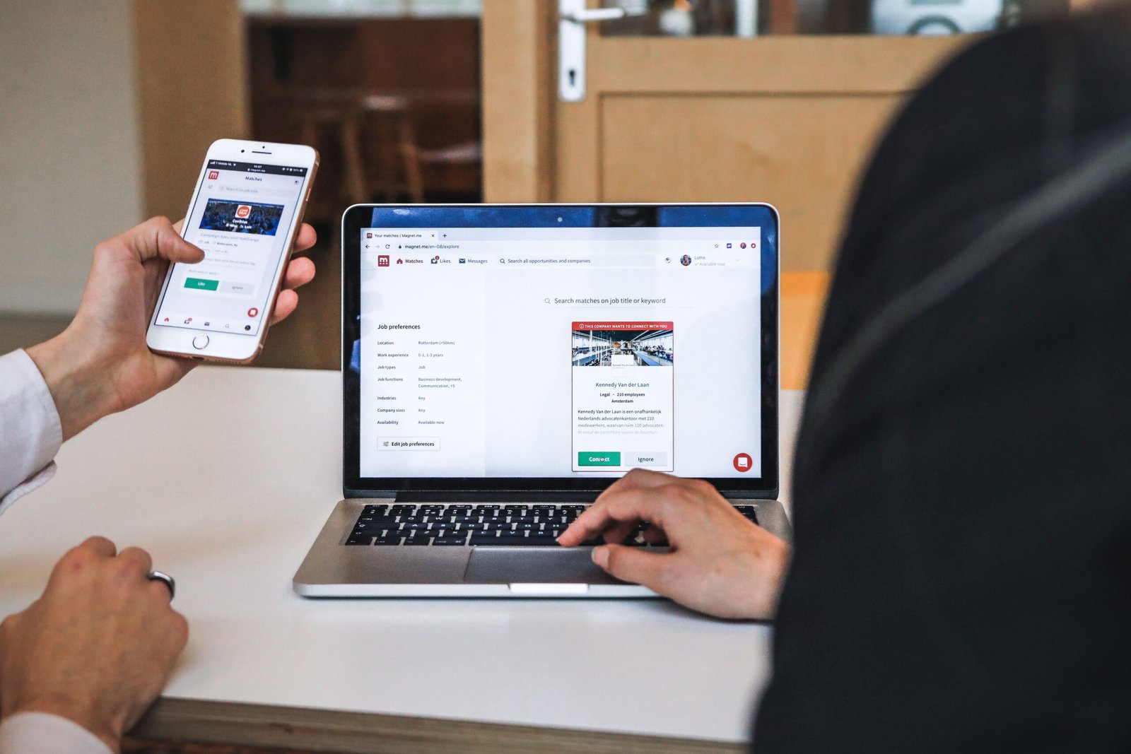 Hands reviewing a website on smartphone and laptop for mobile-first Arusha web design