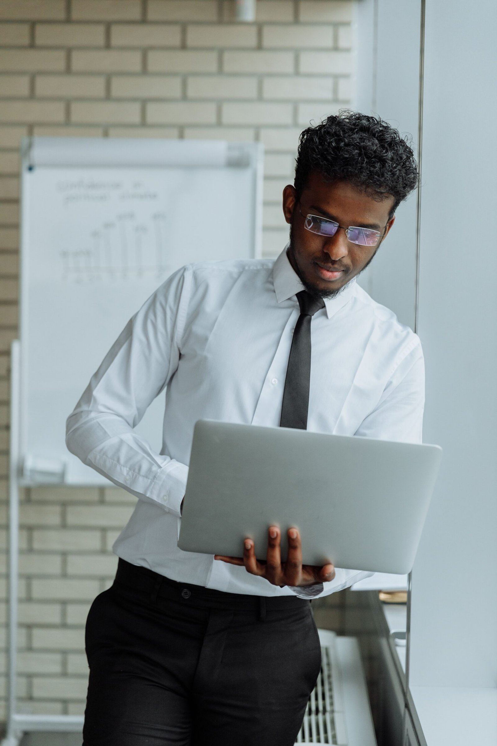 African professional working on a laptop planning website design for an Arusha business
