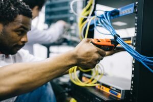 African engineer repairing computer equipment during site maintenance