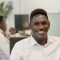 Young African man smiling at his desk in a modern office